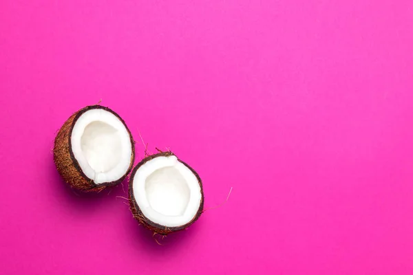 Половинки кокоса на розовом фоне — стоковое фото