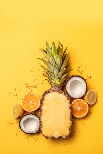 Frutas tropicales planas con piña, naranjas, limón y coco sobre un fondo pastel . — Foto de Stock