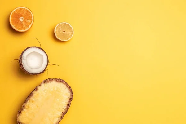 Frutas tropicales planas con piña, naranjas, limón y coco sobre un fondo pastel . — Foto de Stock