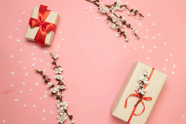 Caja sorpresa regalo con ramitas de flores y pétalos sobre fondo rosa — Foto de Stock