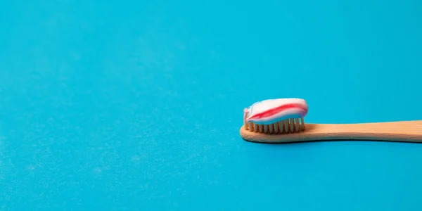 Bamboo natural toothbrush with natural bristles on a blue background. Free copy space. Medical conception — Stock Photo, Image