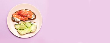 Arka planda peynir ve salatalık ile Balık sandviç.