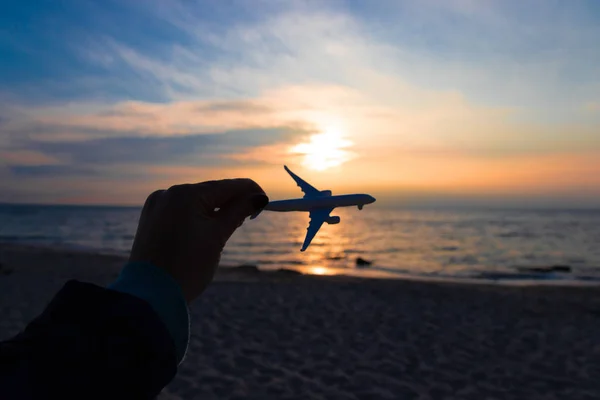 Travel and air transportation concept. Hand with small toy plane.