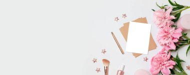 Gri bir arka plan üzerinde pembe şakayık bir buket ile kağıt bir levha ile Zanaat zarf. Düz döşeme, üst görünüm.