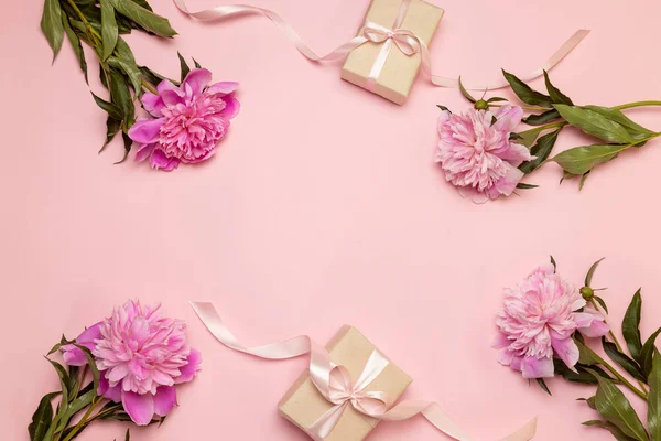 Composición floral primaveral de peonías y regalos sobre un fondo de mesa blanco y rosa — Foto de Stock
