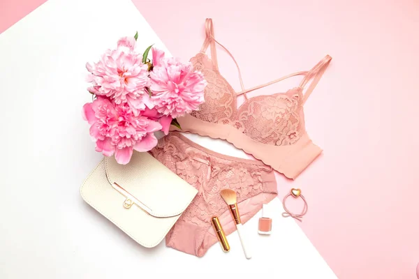 Womens beautiful lacy underwear with accessories, a bouquet of flowers peonies, handbags on a pink and white background. — ストック写真