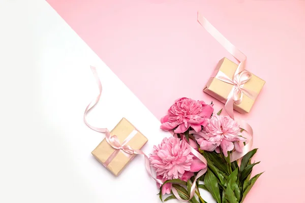 Día de las Madres. Concepto festivo de peonías y regalos sobre un fondo blanco y rosa con espacio para copiar. Usted puede utilizarlo para el texto para la bandera, cartel, sitio . — Foto de Stock