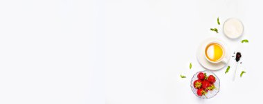 Beyaz fincan çay ve taze çilek, zencefil parçaları, portakal, nane ve şeker gri bir arka plan üzerinde. Düz döşeme, üst görünüm.