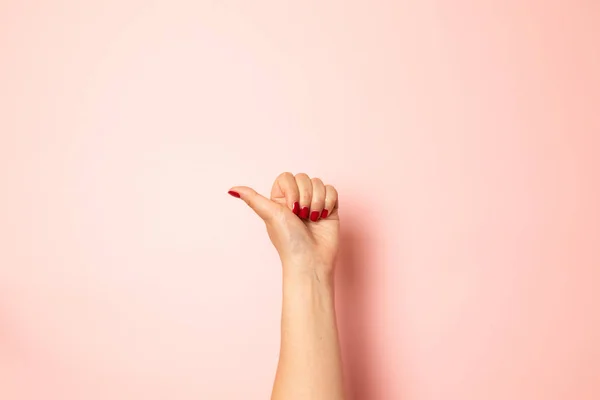 Concepto creativo de likes y remops de redes sociales. Primer plano de la mano femenina mostrando el signo de pulgares hacia arriba sobre un fondo rosa — Foto de Stock