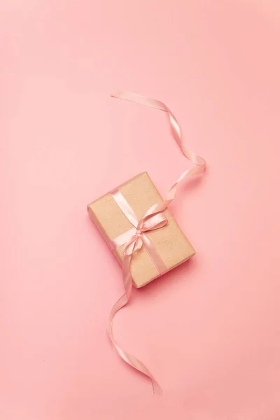 Handwerk Geschenk-Box mit rosa Pastell Schleife auf rosa Leinwand Hintergrund — Stockfoto