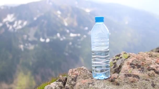 Botella y vaso de agua limpia en la zona de montaña. Tema de salud y ecología — Vídeos de Stock