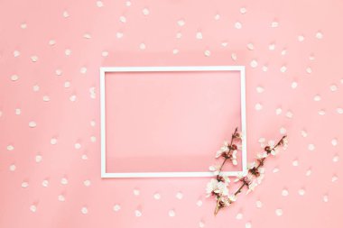 Beyaz çiçekler ile boş çerçeve mockup. Yaratıcı düz, pembe arka planda boş çerçeve mock up ve kiraz ağacı çiçekleri kavramı üst görünümü yatıyordu