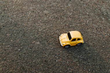 Yaz aylarında güneş ışığında plajda sarı oyuncak araba. Tatil ve seyahat konsepti. Tropikal ada plaj ve araba minyatür Doğum gündoğumu