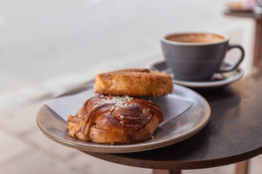 Bir sokak kafede kafede masada yatan tarçın ile kahve ve topuz fincan.