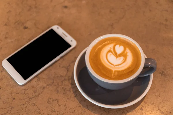 Xícara de café Latte com telefone inteligente — Fotografia de Stock