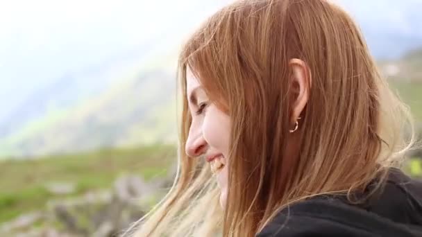 Mira a la chica mirando a la cámara en una montaña cubierta de verde . — Vídeo de stock