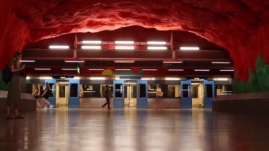 Stockholm, İsveç - 7 Haziran 2019: Solna Centrum metrosu, mavi tren kapıları açık, insanlar biniyor ve treni raylara gönderiyor.