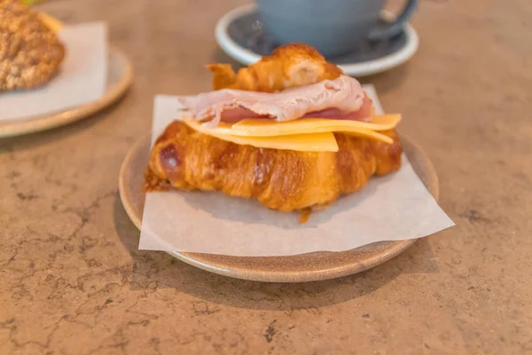 Pequeno-almoço francês. Café e croissant sanduíche na mesa de pedra . — Fotografia de Stock