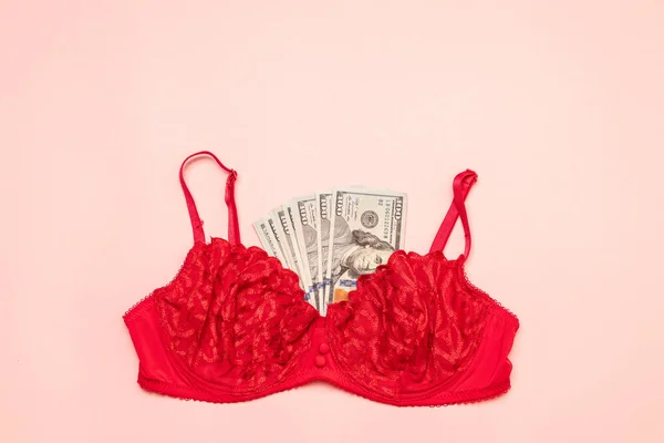 Roter BH mit Geld auf rosa Hintergrund. die Wohnung lag. Modeunterwäsche-Konzept. — Stockfoto
