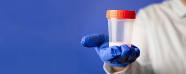 Doktor tıbbi analiz için spermli plastik bir kap tutuyor. Suni döllenme