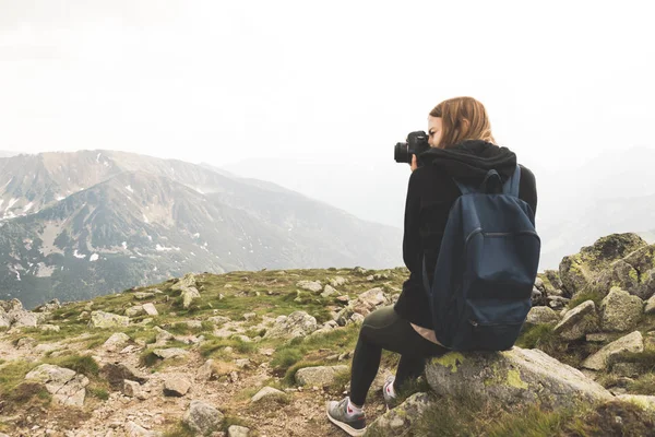 Gadis muda dengan sweater hitam dan legging berdiri di pegunungan dan foto-foto sifat kecantikan . — Stok Foto