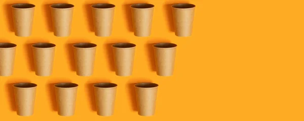 Mintás papír csészék narancssárga háttérrel és másolási tér — Stock Fotó