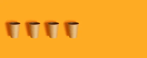 Mintás papír csészék narancssárga háttérrel és másolási tér — Stock Fotó