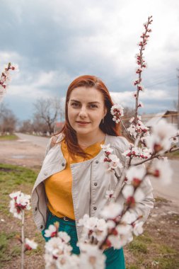 Bir bahar çiçekli bahçede kızıl saçlı kız