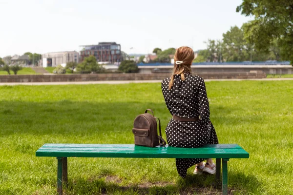Bir park bankında bir elbise yalnız kız, bir tatil sahiptir. — Stok fotoğraf