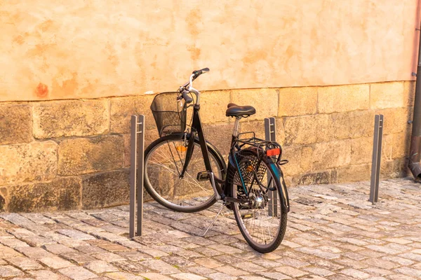 Schwarzes Fahrrad geparkt gegen gelbe Wand in der Straße von Stockholm — Stockfoto