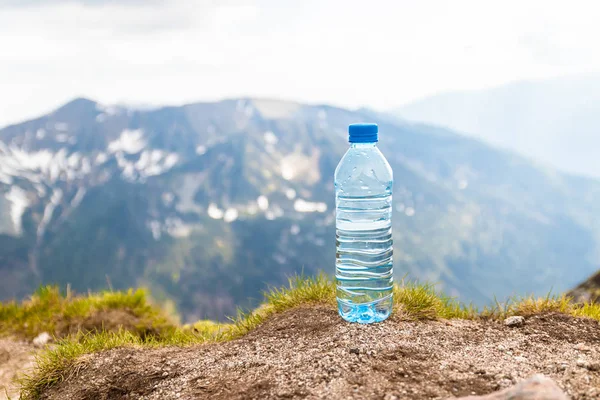 Pure water in plastic bottles on the stone against the background of a picturesque view Zakopane Tatra Mountains