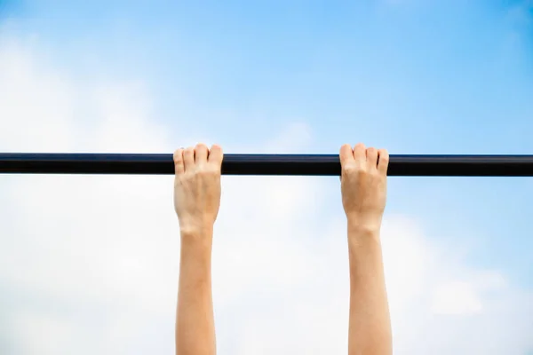 Girl passes the standards for pulling up on a horizontal bar in the park sunny day. — Stock Image Girl passes the standards for pulling up on a horizontal bar in the park sunny day. Royalty Free Stock Photos
