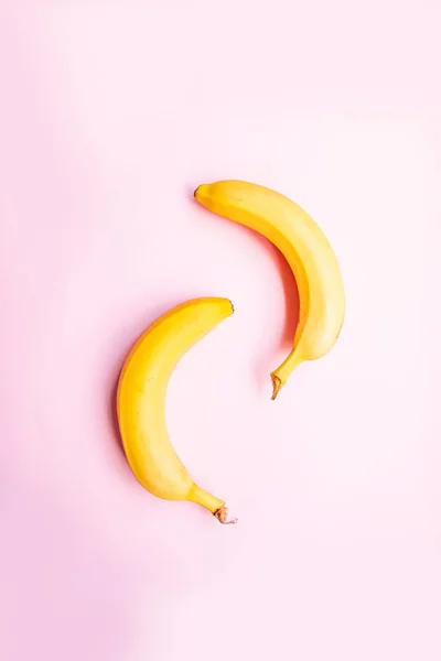 Плоский шар двох бананів на рожевому фоні . — стокове фото