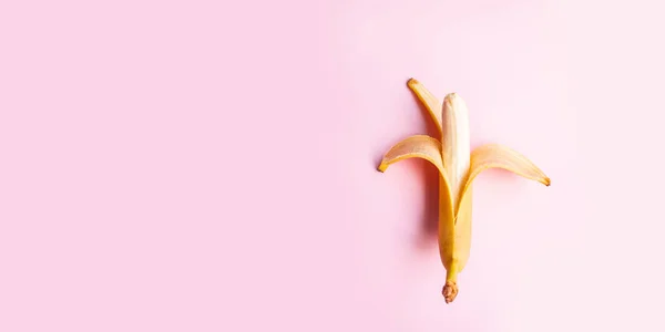 Nyári vitamin-koncepció. Lakás összetétele édes nyitott banán rózsaszín háttérrel és másolási hely a szöveghez. — Stock Fotó