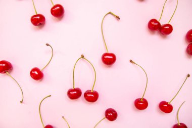 Pembe bir arka plan üzerinde kiraz düz yatıyordu yapılmış Yaratıcı düzen.