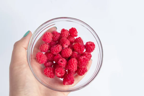 Fresh raspberries in a glass bowl and natural yogurt on a white table. — Stock Photo, Image