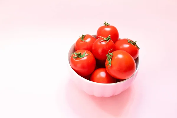 Tomates frescos en un plato sobre un fondo rosado. Dieta Saludable Vitaminas Bio Alimentos — Foto de Stock