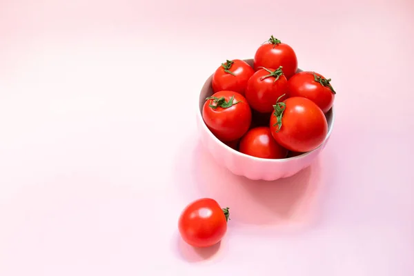 Różowa ceramiczna miska z dojrzałymi czerwonymi pomidorami na różowym tle. Zdrowa dieta witaminy Bio Foods — Zdjęcie stockowe