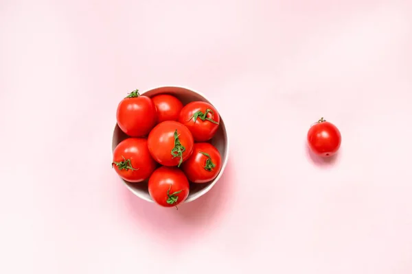 Tazón de cerámica rosa con tomates rojos maduros sobre un fondo rosa. Dieta Saludable Vitaminas Bio Alimentos — Foto de Stock