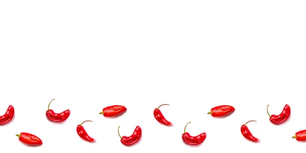 Spousta červených chilli papriček na bílém pozadí. — Stock fotografie