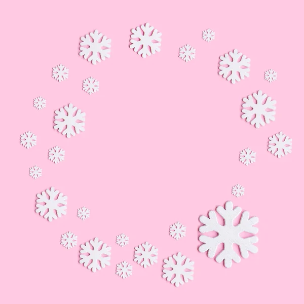 Téli összetétele hópelyhek a pasztell rózsaszín háttér. Lapos feküdt, felülnézet. — Stock Fotó