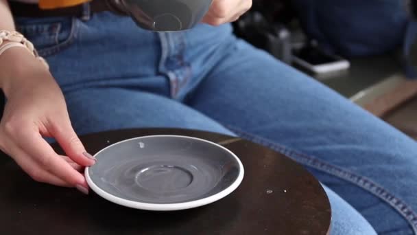 Young woman hands taking a white cup of coffee or cappuccino from a table in a street restaurant — Stock Video