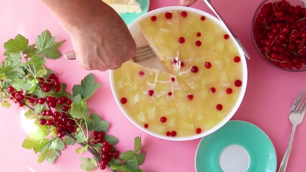 Top view of a female hand with a knife cuts a delicious dessert cake with fruit. — Stock Video