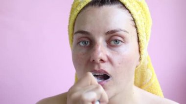 Bir duş sonra havlu genç kız dişlerini fırçalar. Sabah öz bakım