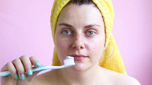 Młoda dziewczyna w ręczniku po prysznicem szczotek zębów. Rano samoopieki — Wideo stockowe