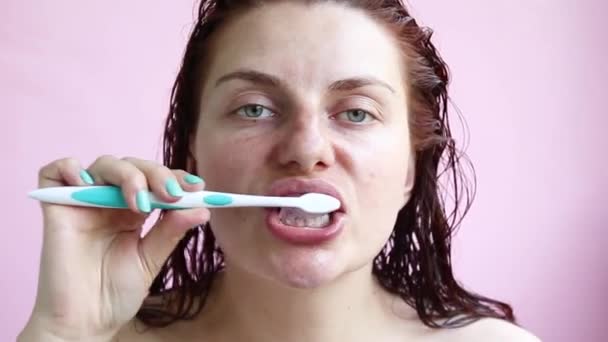 Ung flicka i en handduk efter en dusch borstar tänderna. Morgon egenvård — Stockvideo