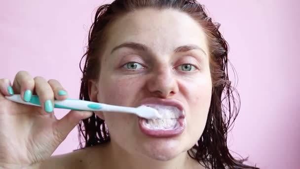 Fiatal lány egy törülközővel után zuhany kefék fogát. Reggel öngondoskodás — Stock videók