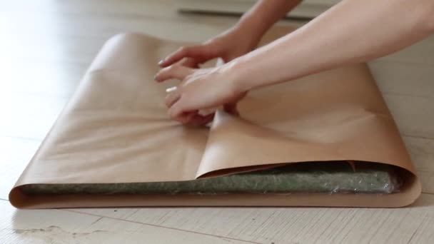Las manos femeninas envuelven un regalo en papel de regalo artesanal . — Vídeos de Stock