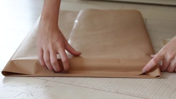 Mãos femininas embrulhar um presente em papel de presente artesanal . — Vídeo de Stock