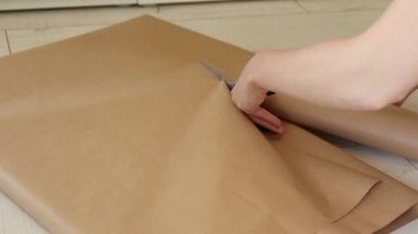 Kadın elleri zanaat hediye kağıdı kesti. Yeni yıl, doğum günü veya noel için hazırlık